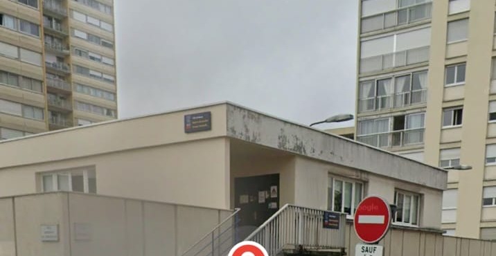 Le bâtiment de la salle vu de près, l'escalier extérieur et la porte d'entrée en haut